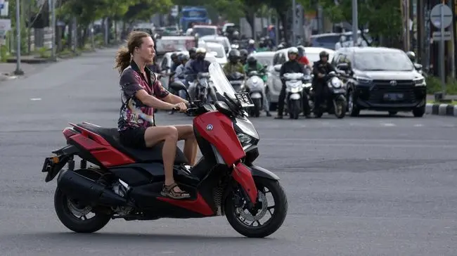Tourist riding scooter without helmet in Bali